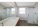 Bright bathroom with dual sinks, a large mirror, and two glass-enclosed showers at 5702 Saratoga Pl, Plainfield, IN 46168