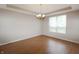 Bright dining room featuring hardwood floors, a chandelier, and a large window offering ample natural light at 5702 Saratoga Pl, Plainfield, IN 46168