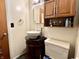 A bathroom with dark vanity, unique vessel sink, and coordinating wooden medicine cabinet at 5817 Oliver Ave, Indianapolis, IN 46241