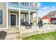 Inviting front porch with black rocking chairs, white planters, and dark front door at 5954 Crowley Pkwy, Whitestown, IN 46075