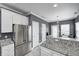 Gray and white kitchen features stainless steel appliances, granite counters, and ample cabinet space at 5954 Crowley Pkwy, Whitestown, IN 46075