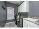 Laundry room boasts modern washer and dryer, with ample counter space and storage cabinets at 5954 Crowley Pkwy, Whitestown, IN 46075
