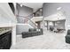 Open-concept living room with a fireplace, staircase with dark wood railing, and a view into the dining area at 5954 Crowley Pkwy, Whitestown, IN 46075