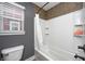 Bathroom with a combined tub and shower, featuring tiled walls, a shower curtain, and natural light at 5954 Crowley Pkwy, Whitestown, IN 46075