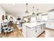 Open-concept kitchen flows into the living and dining areas, showcasing pendant lighting and a large island at 6040 Juniper Ct, Whitestown, IN 46075