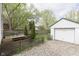 Landscaped backyard showcasing a deck, a gravel area, a privacy fence, and a detached one car garage at 6180 Crittenden Ave, Indianapolis, IN 46220