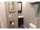 Stylish half bathroom with dark vanity, seahorse artwork, gray walls, and modern fixtures and toilet at 6180 Crittenden Ave, Indianapolis, IN 46220