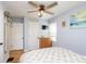 Bedroom with hardwood floors, ceiling fan, dresser, and natural light from the large windows at 6180 Crittenden Ave, Indianapolis, IN 46220
