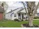 Charming one-story home with cozy porch and manicured lawn, framed by mature trees at 6180 Crittenden Ave, Indianapolis, IN 46220