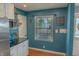Kitchen area featuring teal walls, stainless steel appliances, butcher block shelving, and natural light from a window at 6180 Crittenden Ave, Indianapolis, IN 46220