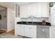 This kitchen boasts white cabinets, black countertops, stainless steel dishwasher, and hardwood floors at 6180 Crittenden Ave, Indianapolis, IN 46220