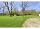 Lush backyard featuring a vibrant lawn and mature trees, perfect for outdoor activities and relaxation at 6315 Shelbyville Rd, Indianapolis, IN 46237