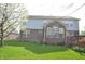 Backyard view features sunroom, deck, mature trees, and grassy lawn at 6527 Briarwood Pl, Zionsville, IN 46077