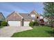 Charming brick two-story home with a three-car garage and a well-manicured lawn at 6527 Briarwood Pl, Zionsville, IN 46077