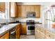 Well-lit kitchen showcasing stainless steel appliances and wood cabinetry at 6527 Briarwood Pl, Zionsville, IN 46077
