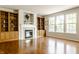Bright living room with hardwood flooring, a fireplace, and built-in bookshelves at 6527 Briarwood Pl, Zionsville, IN 46077