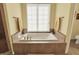 Bright bathroom featuring a large soaking tub under a window with privacy blinds at 6829 Whitetail Woods Ct, Bargersville, IN 46106