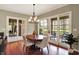 Bright dining room boasts a hardwood floor, glass doors, and a modern chandelier at 6829 Whitetail Woods Ct, Bargersville, IN 46106