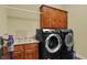 Laundry room with overhead cabinets, sink, and modern washer and dryer at 6829 Whitetail Woods Ct, Bargersville, IN 46106