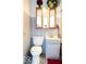Compact bathroom with a toilet, vanity with sink, mirror cabinet, and patterned floor at 7108 Hearthstone Way, Indianapolis, IN 46227