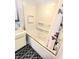Clean white bathroom features a soaking tub with gold trim and a black and white patterned rug at 7108 Hearthstone Way, Indianapolis, IN 46227