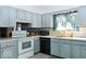 Functional kitchen with bright blue cabinets, laminate countertops, and essential appliances at 7108 Hearthstone Way, Indianapolis, IN 46227