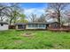 Large backyard featuring a fire pit and a sunroom off the back of the home at 7212 E Pleasant Run Pkwy S Dr, Indianapolis, IN 46219