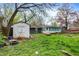 Spacious backyard showcasing a shed, firepit, and a sunroom attached to the house at 7212 E Pleasant Run Pkwy S Dr, Indianapolis, IN 46219