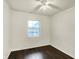 Bright bedroom features a ceiling fan, window, and wood-look flooring at 7212 E Pleasant Run Pkwy S Dr, Indianapolis, IN 46219