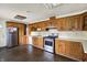 Eat-in kitchen featuring oak cabinets, stainless steel appliances, and tile countertops at 7212 E Pleasant Run Pkwy S Dr, Indianapolis, IN 46219