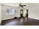 Bright living room featuring hardwood floors, white walls, a ceiling fan, and a large window at 7212 E Pleasant Run Pkwy S Dr, Indianapolis, IN 46219