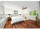 Bedroom features hardwood floors, a ceiling fan, a comfortable bed, and bright windows with natural light at 7456 Heather Ct, Nineveh, IN 46164