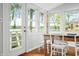 Bright dining area with water views featuring large windows and a wooden table with white chairs at 7456 Heather Ct, Nineveh, IN 46164