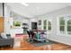 Open kitchen with stainless steel appliances, white cabinets, island with seating, and hardwood floors at 7456 Heather Ct, Nineveh, IN 46164