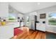 Eat-in kitchen featuring wood floors, white cabinets, stainless appliances, and natural light at 7456 Heather Ct, Nineveh, IN 46164