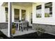 Outdoor seating on a covered patio with views of the backyard and a light-colored house with light stone details at 769 Rose Garden Way, Westfield, IN 46074