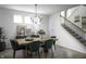 Bright and airy dining room with modern chandelier, hardwood floors, staircase, and large windows at 769 Rose Garden Way, Westfield, IN 46074
