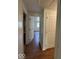 Hallway with a view into bedroom and bathroom featuring wood laminate flooring at 7833 Broadview Dr, Indianapolis, IN 46227