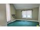 Small bedroom with green walls, carpeted floors, and a window overlooking the backyard at 8200 E Desoto St, Muncie, IN 47303