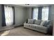 Relaxing living room with natural light, a comfortable sofa, and cozy carpet create an inviting atmosphere at 8200 E Desoto St, Muncie, IN 47303