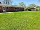 Beautiful backyard with a well-kept lawn and a view of the brick home, great for outdoor enjoyment at 8230 E 11Th St, Indianapolis, IN 46219