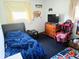 Cozy bedroom featuring comfortable furnishings, gaming chair, and TV for entertainment at 8230 E 11Th St, Indianapolis, IN 46219