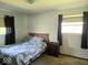 Bright bedroom with a bed, side table, and two windows at 8230 E 11Th St, Indianapolis, IN 46219