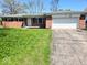 Charming brick home featuring a well-maintained front lawn and an attached two-car garage at 8230 E 11Th St, Indianapolis, IN 46219