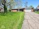 Beautiful home with a well-maintained front yard, driveway, and attached garage, offering ample parking at 8230 E 11Th St, Indianapolis, IN 46219