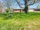 Attractive home with a lush front lawn and mature trees, creating a welcoming and serene atmosphere at 8230 E 11Th St, Indianapolis, IN 46219