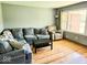Comfortable living room featuring hardwood floors, a large window, and a comfortable sectional at 8230 E 11Th St, Indianapolis, IN 46219