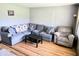 Bright living room featuring hardwood floors, a cozy sectional, and a comfortable reclining chair at 8230 E 11Th St, Indianapolis, IN 46219