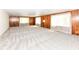 Generously sized living room with classic wood paneling, large windows, and neutral carpeting at 830 N 16Th St, Elwood, IN 46036