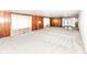Open living area with wood-paneled accent walls, neutral carpet, and access to the outdoors at 830 N 16Th St, Elwood, IN 46036